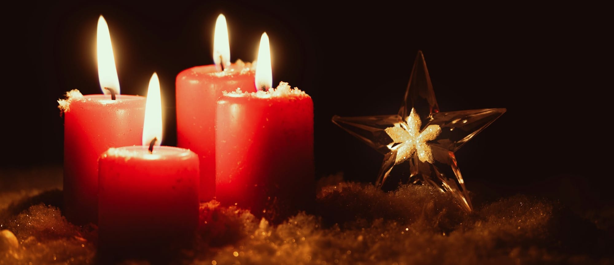 a group of red candles sitting next to a star