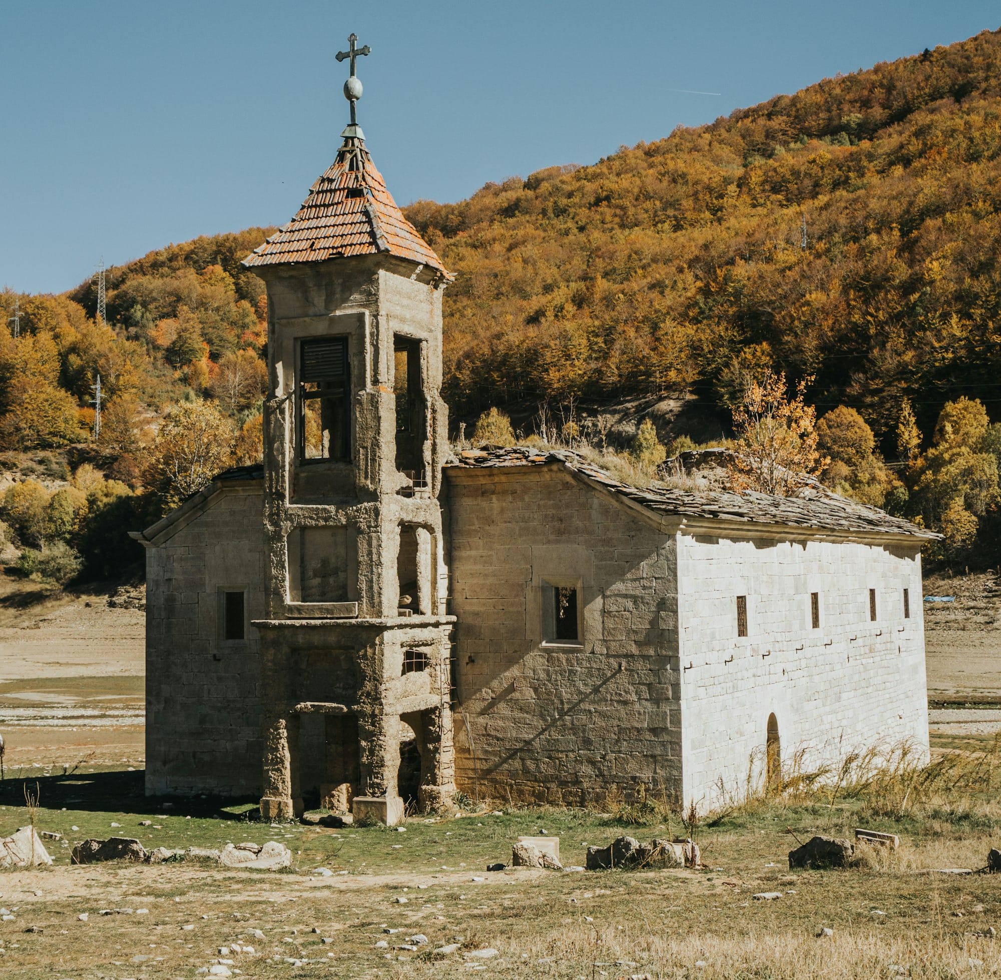 white and brown concrete building near green trees under blue sky during daytime